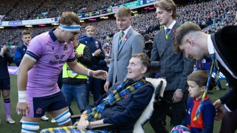 Doddie Weir delivers the match ball during an Autumn Nations Series match between Scotland and New Zealand at BT Murrayfield