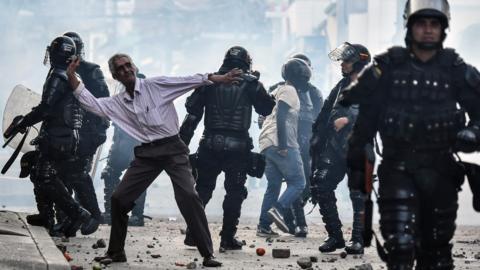 A demonstrator throws stones during a protest against a campaign rally by Timochenko in Yumbo, Colombia, on February 7, 2018