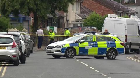 A cordon and police vehicles