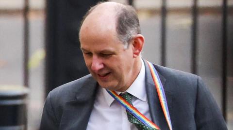 Sir Philip Barton looks toward the ground as he walks along Downing Street