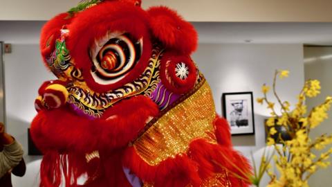 Chinese lion dancers inside a Birmingham office building