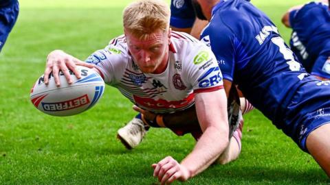 Zach Eckersley extends his right arm to touch the ball down and score Wigan's opening try against Toulouse