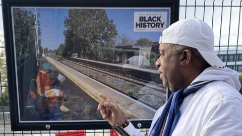 A man observes one of the photos on exhibit at Gloucester train station