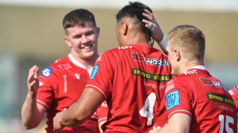 Sam Lousi of Scarlets celebrates scoring a try