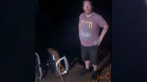 Paul Clark with the office chair after it was removed from the lake