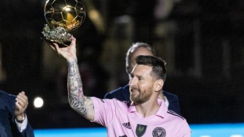 Lionel Messi holds aloft the Ballon d'Or trophy before an Inter Miami friendly