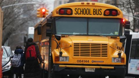 Students walk to board a school bus in Manhattan's East Village in New York City.