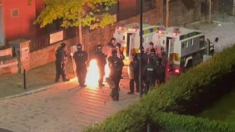 A petrol bomb is thrown at riot police in Nailors Row, Derry