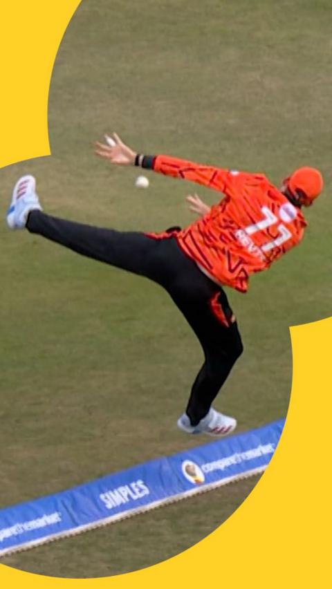 Matthew Revis jumping over the boundary to stop a six