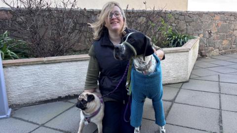 Lynn Symphorien knelt down next to her two dogs Macy and Rumer. 