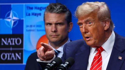 Donald Trump with Pete Hegseth in background