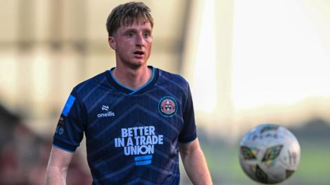A photo of Jevon Mills, wearing a blue Bohemians kit, watching the ball during their game against Derry City in May 2024