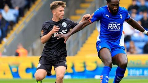 Will McGowan challenges Oldham Athletic's Emmanuel Monthe for the ball during a National League game