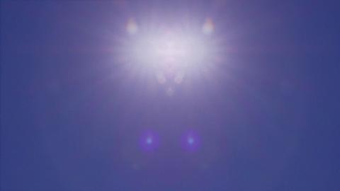 Shot of a dazzling white blurred sun sitting high in the sky on a bright blue summer's day 