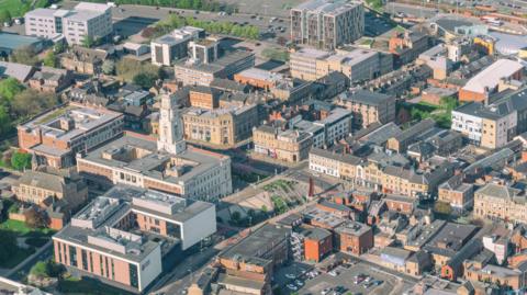 An aerial view of Barnsley, with houses, flats, car parks and roads in view.