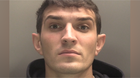 Police mugshot showing Jake Joseph, who has brown hair and a black hoodie