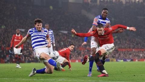 Holmes (left) challenges Wout Weghorst whilst playing for Reading against Manchester United