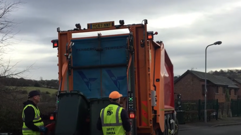 Refuse collectors in Bradford loading lorry