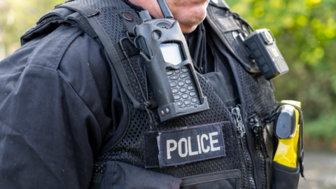 A black police jacket with a yellow taser handle