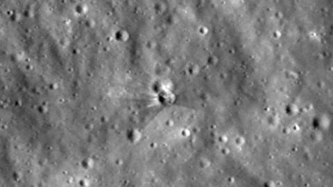 A photograph of the surface of the moon shows a newly formed crater