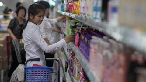 In a photo taken on June 4, 2017 a woman checks products on display at the Kwangbok, or 'liberation', department store in Pyongyang.
