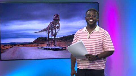 De-Graft in the studio with a dinosaur in the screen