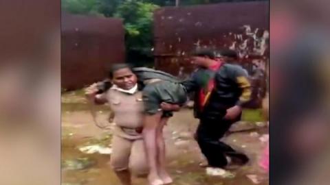 Police inspector Rajeshwari carries an unconscious man on her shoulder.