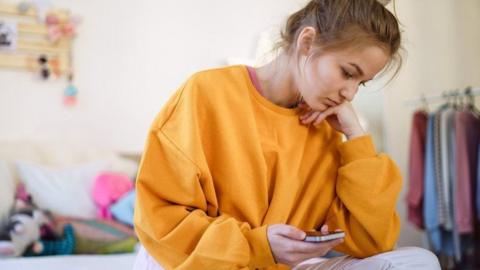 Girl sits on bed