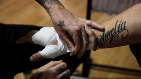 Bare-knuckle fighter having hand wrapped ahead of a fight