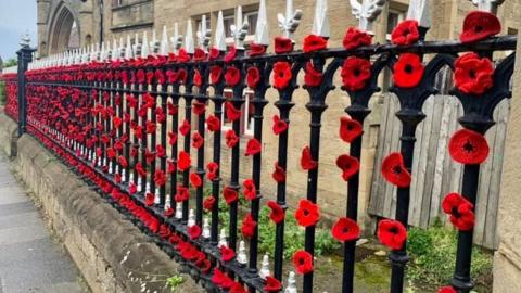 Knitted and crocheted poppies at Hebburn Cemetery gates