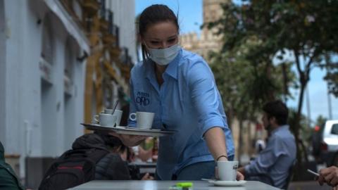 Woman serving coffee outside a bar