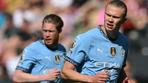 Manchester City striker Erling Haaland in the foreground of the picture with  Kevin de Bruyne in the background