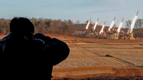 Kim Jong Un watching rocket launcher drills