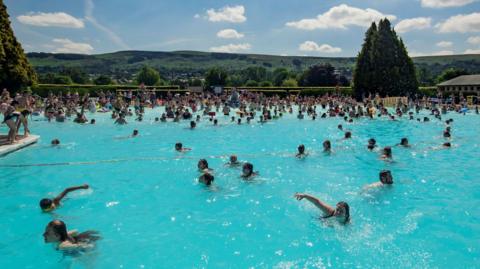 Dozens of people swimming and playing in the water at Ikley Lido.