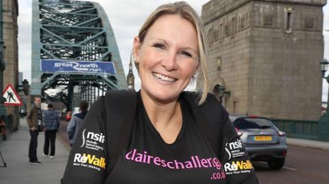 Claire is stood nearby to a bridge smiling into the camera during the Great North Run