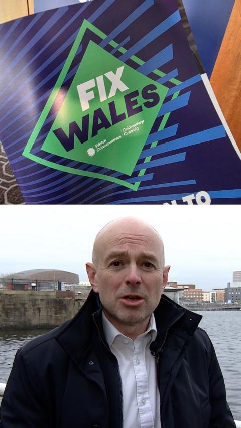 The image is split in half. One the top is a picture of the Tories manifesto that says 'Fix Wales in bold letters. The manifesto is predominately blue but has a green diamond pattern in the middle. On the bottom of the image there is a man wearing a white shirt with the top button undone and a dark navy blue coat, he is looking into the camera and has a bald head.
