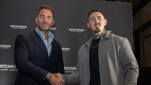 Eddie Hearn and Tom Aspinall shake hands and look at the camera