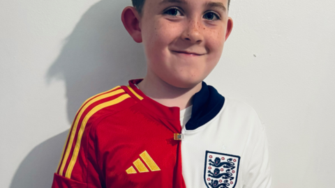 A boy in half England shirt, half Spain shirt