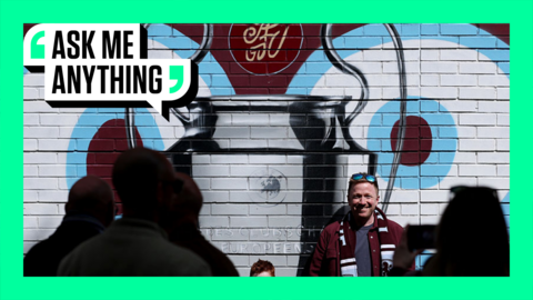Aston Villa Fans stands in front of wall art of Champions League trophy, with banner surrounding in pale green with Ask Me Anything graphic