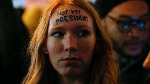 A woman looks on as she takes part in a protest against President-elect Donald Trump in front of Trump Tower in New York, 10 November