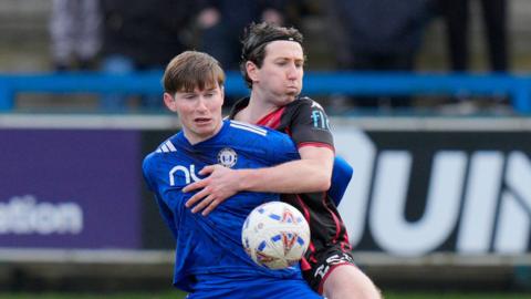 Shaun Donnellan of Truro City competes for the ball with Will Harris of FC Halifax Town