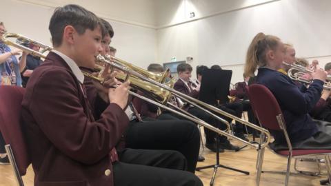 boy plays trombone