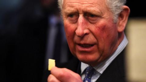 The Prince of Wales holding a piece of cheese
