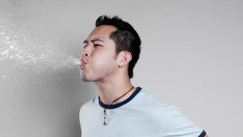 A man spitting out water