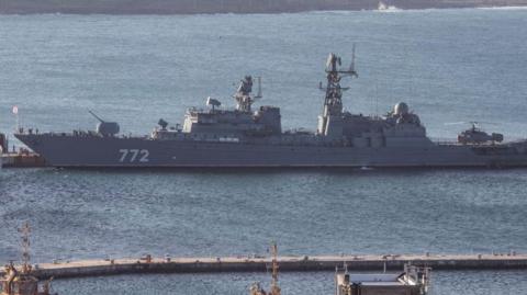 The Russian Neustrashimy frigate - a long, grey vessel with the number 772 printed on the side in white - in the water.