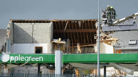 Two firefighters are seen near the blast site in October 2022