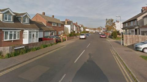 A residential street lined with houses with double yellow lines along the road and a sign saying "Anchor Road"