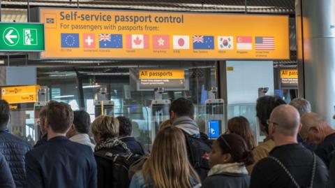 Passengers waiting at Amsterdam Airport passport control