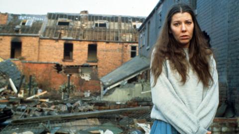 Karen Meagher as Threads character Ruth Beckett, standing amid rubble and destroyed buildings