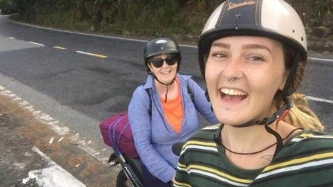 Jodi Jayne Walsham is in the foreground and is wearing a striped top and a helmet. Her Mum Jayne Walsham is on a bike behind her. She is wearing a blue top and a helmet  